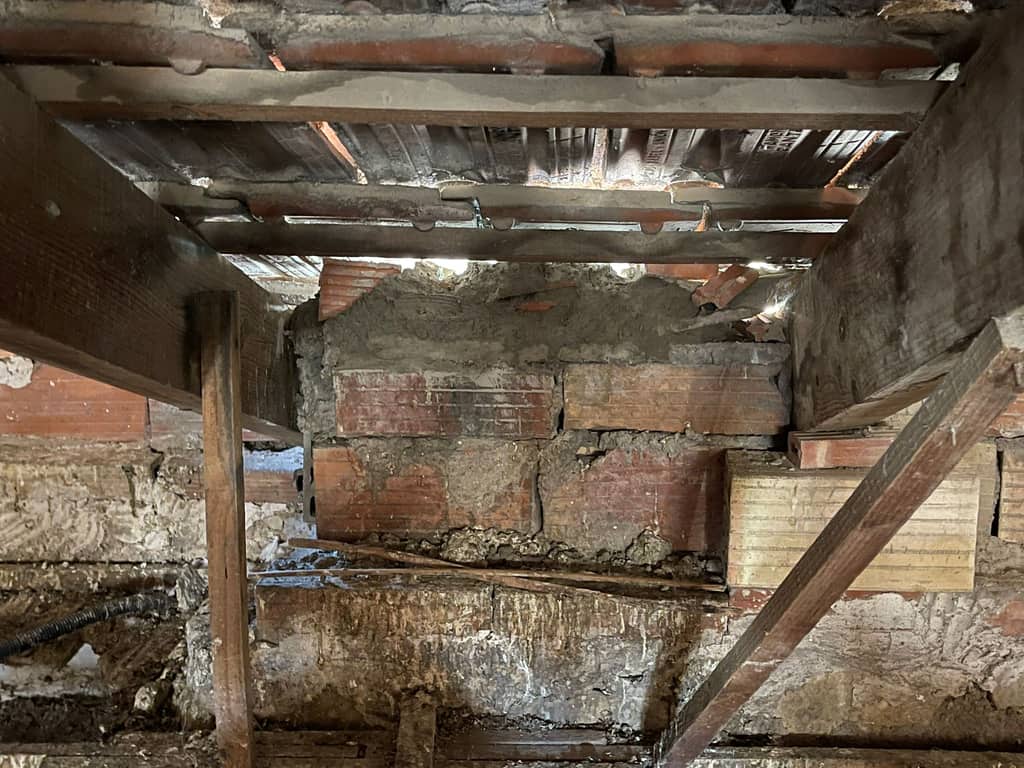 Estructura de la cubierta vista desde abajo: mortero disgregado, ladrillo degradado y huecos por los que entra la luz entre las tejas